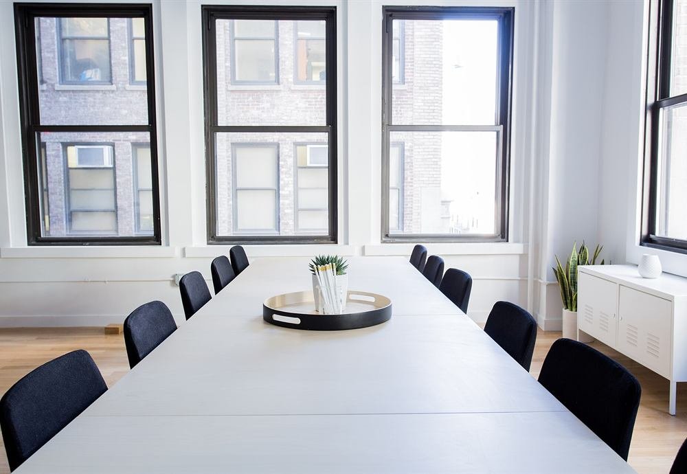 A bright meeting room with a long table and a window view
