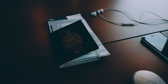 A passport and papers on a dark desk