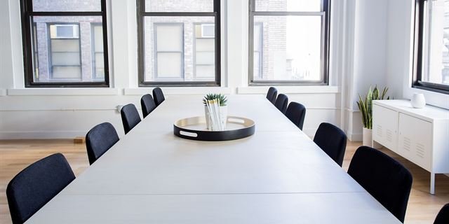 A meeting room with a long table where paperwork is reviewed